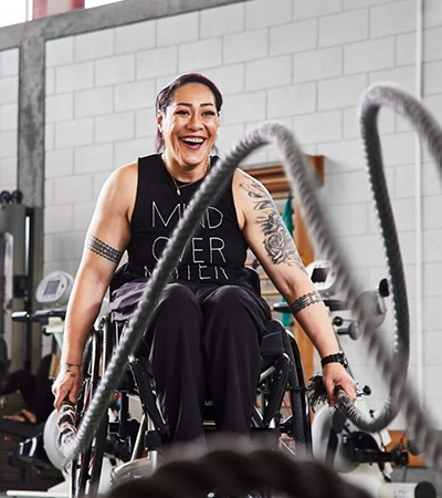 Smiling woman in wheelchair working out at a gym